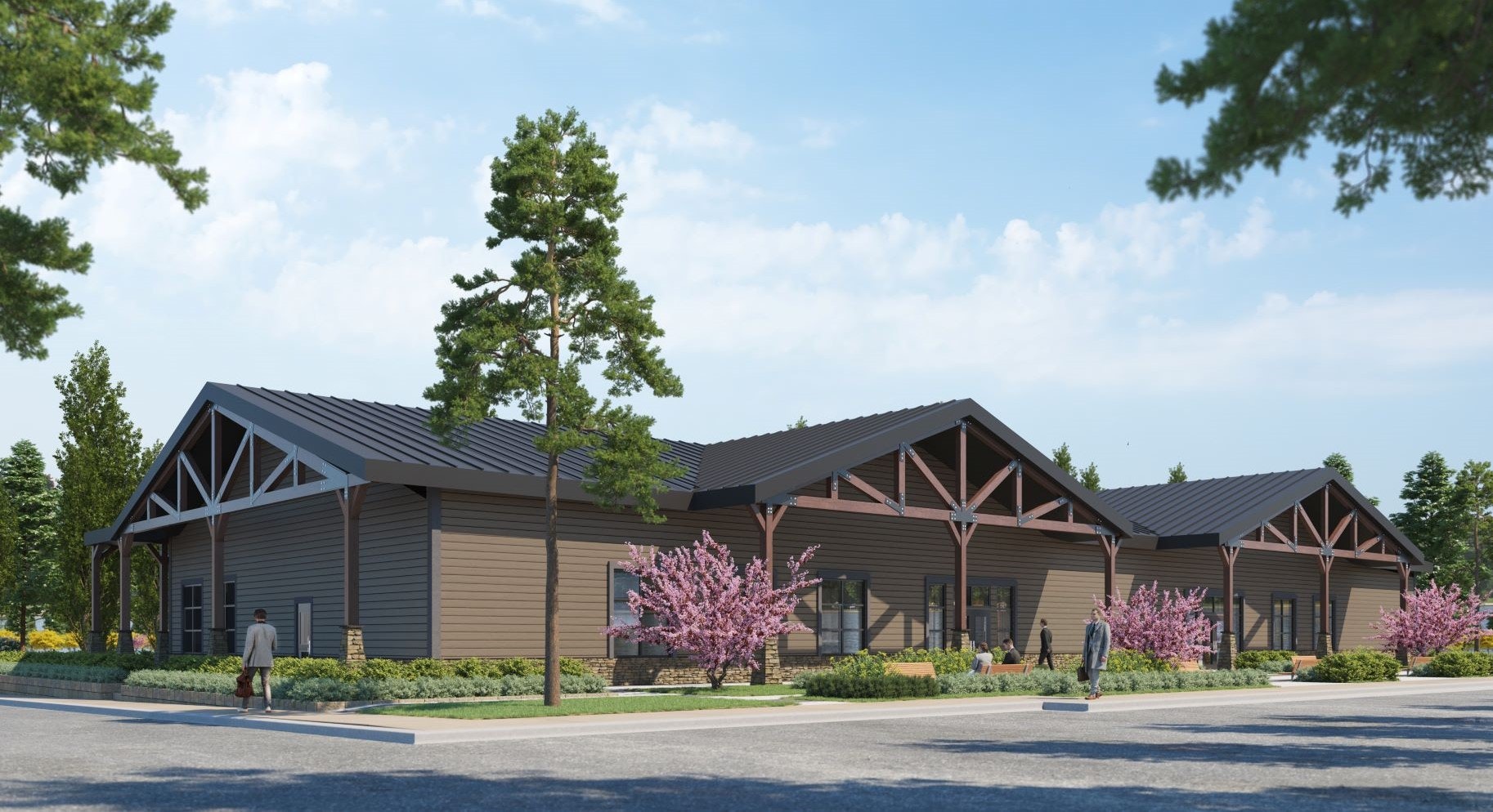 A modern, single-story building with a dark roof, surrounded by trees and shrubs, with people walking nearby.