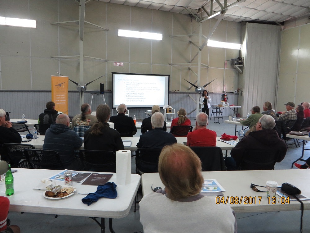 A group of people seated watching a presentation in a workshop or seminar setting.