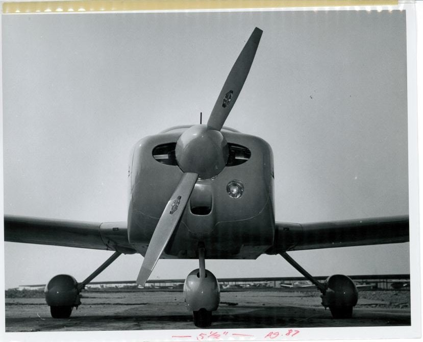 A front view of a small propeller aircraft on a runway.