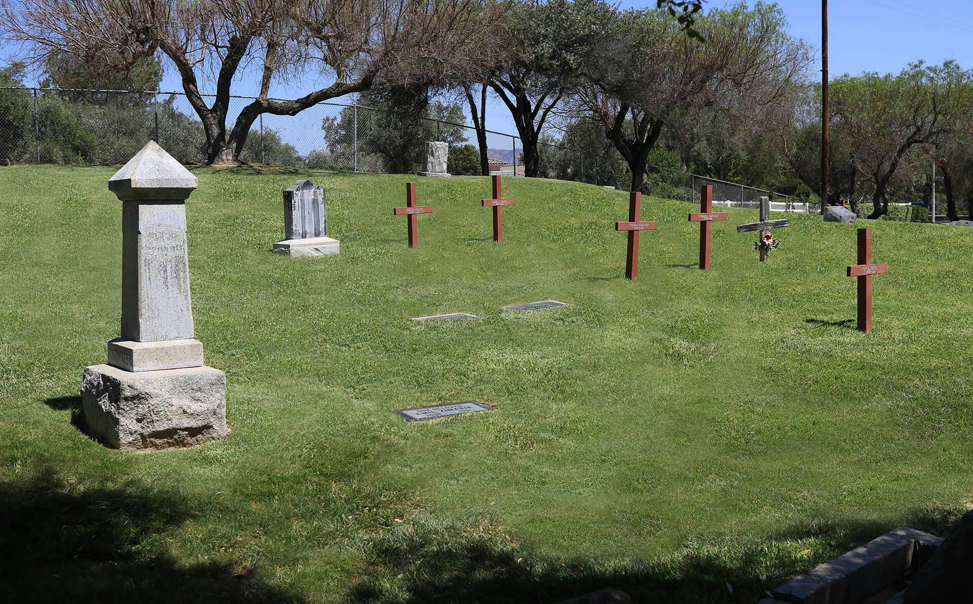May contain: graveyard, outdoors, gravestone, tomb, cross, and symbol