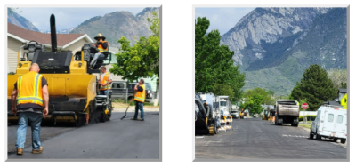 Workers paving a road with heavy machinery, alongside a mountainous landscape.