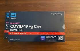 COVID-19 home test kit box on a wooden table.