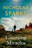 Book cover titled "Counting Miracles" by Nicholas Sparks, featuring a person and dog walking on a grassy path with a house and trees.