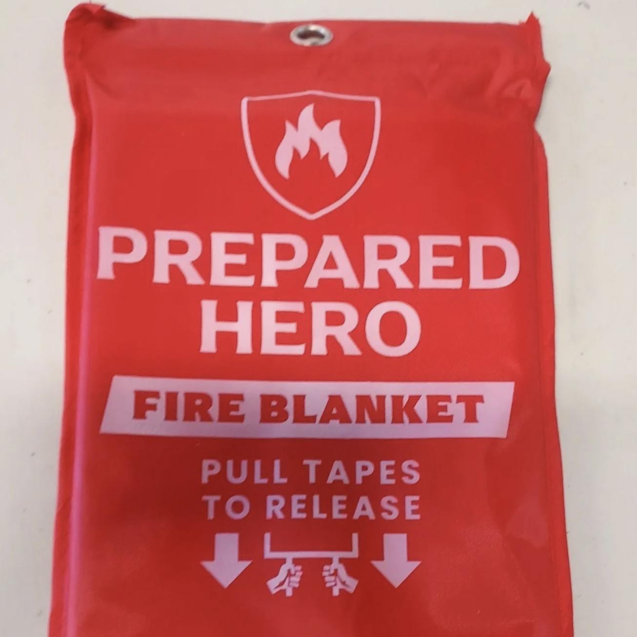 Red fire blanket pouch with "PREPARED HERO" text and instructions to pull tapes to release.