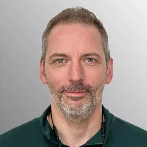 a man with short hair and close trimmed beard
