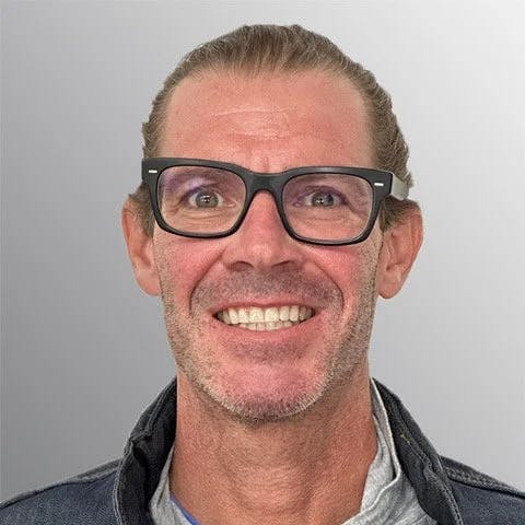smiling man with glasses, short hair, and short facial hair