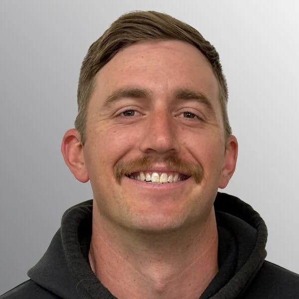 smiling man with short hair and mustache