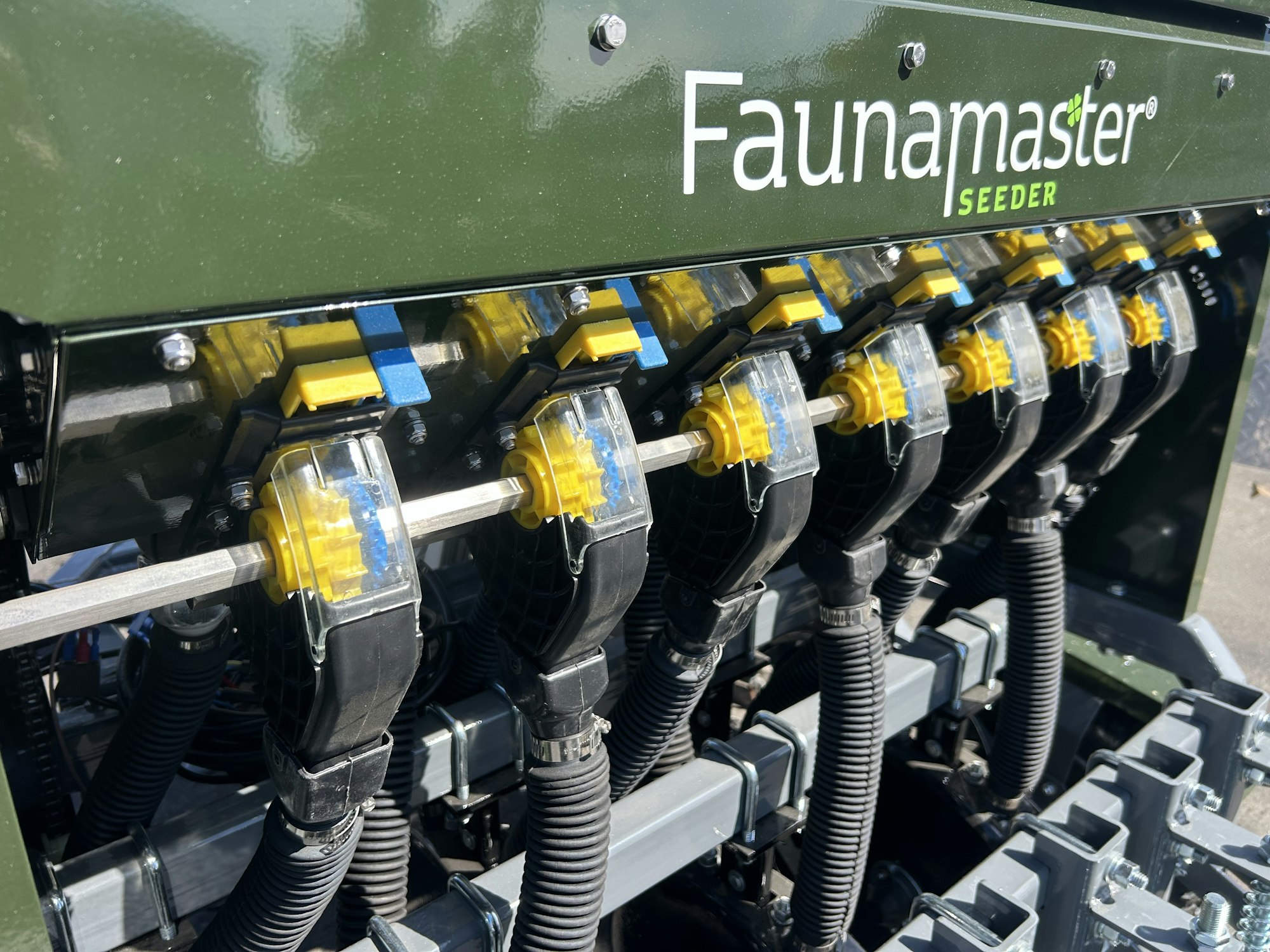 Faunamaster Seeder machine with multiple yellow and black seeding mechanisms and tubes.
