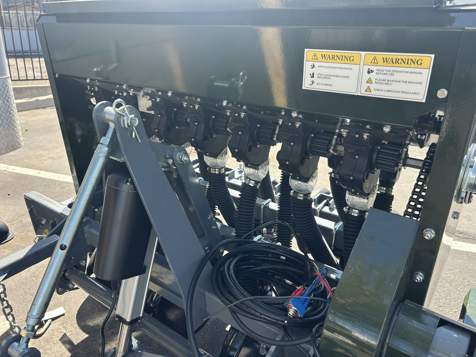 Industrial machine with multiple components, warning signs, and cables.