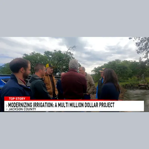 A group of people discussing near a river, related to a modernization irrigation project in Jackson County, as shown on a news segment.