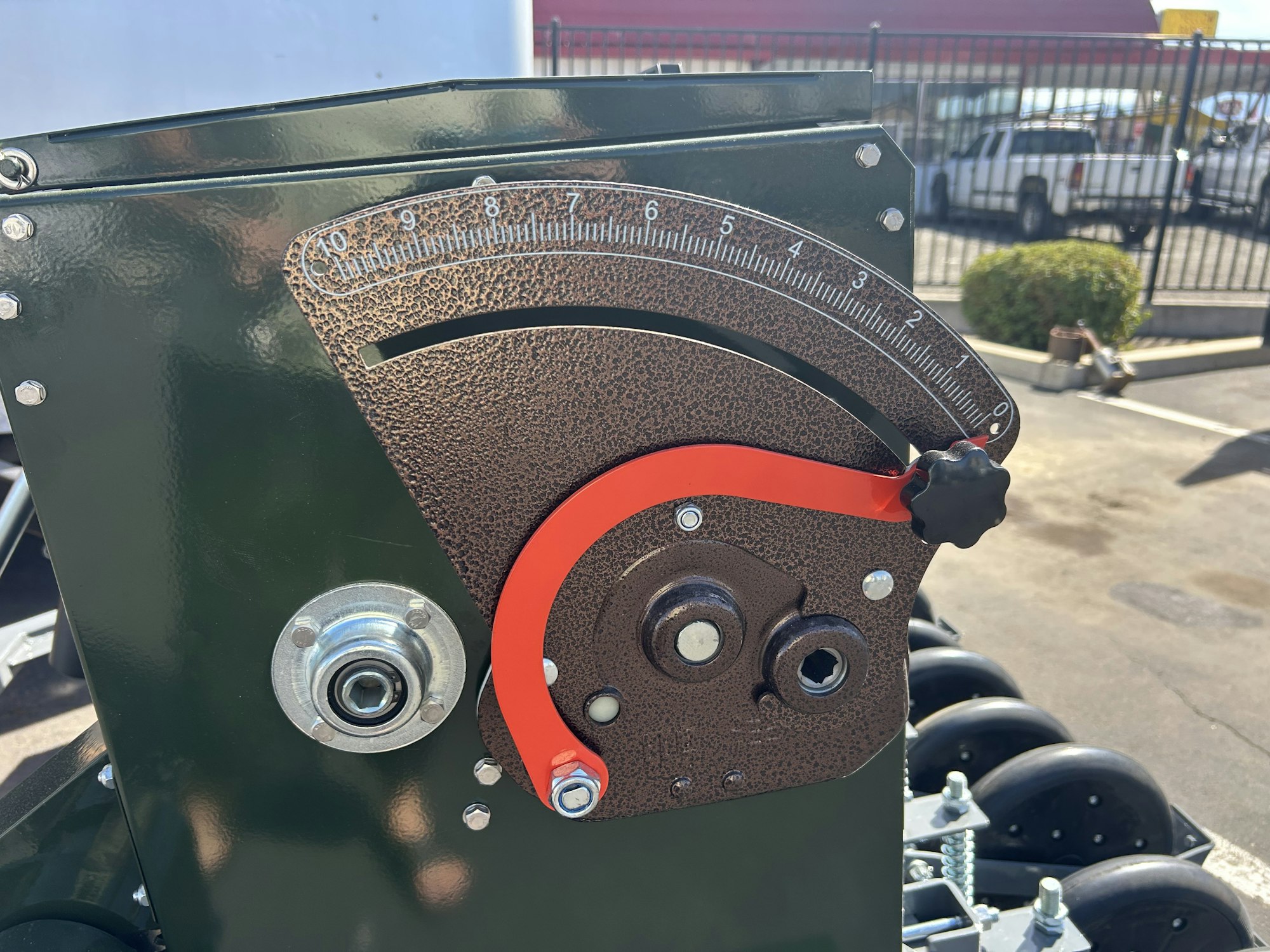 A close-up of a mechanical angle gauge with a red indicator on a graduated scale and adjustment knob.