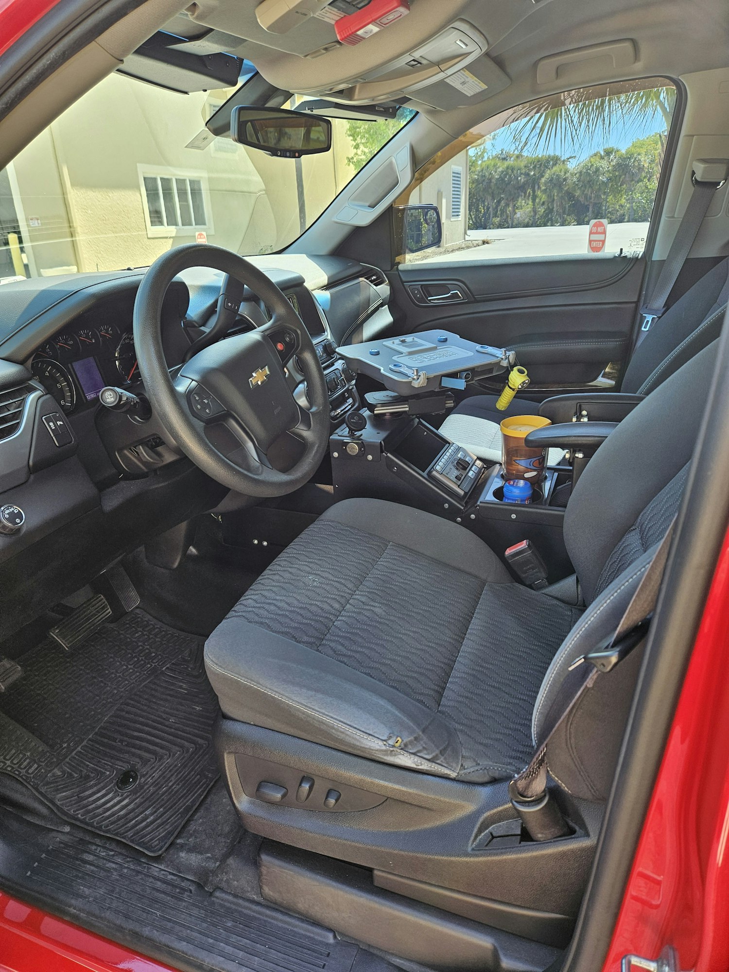 Interior of a vehicle, steering wheel, dashboard, driver's seat, and side mirror visible.