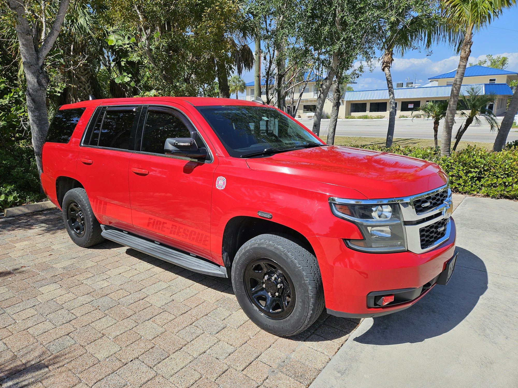 A red Fire Rescue SUV parked outdoors on a sunny day.