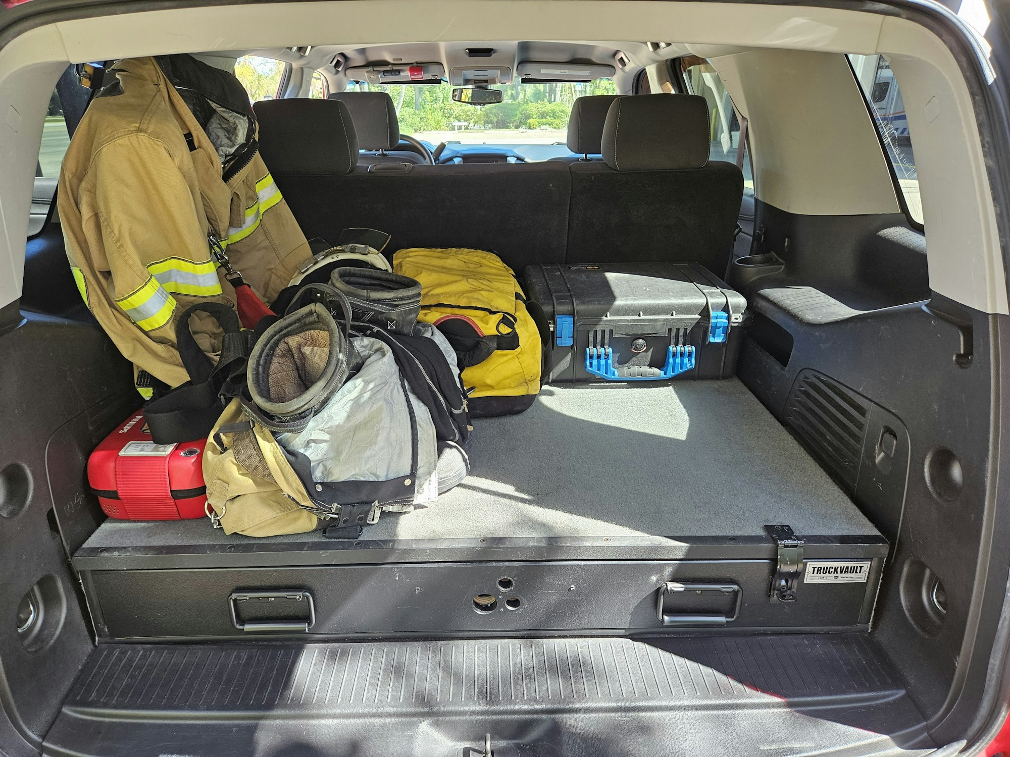 Firefighter gear and equipment stored in the back of a vehicle.
