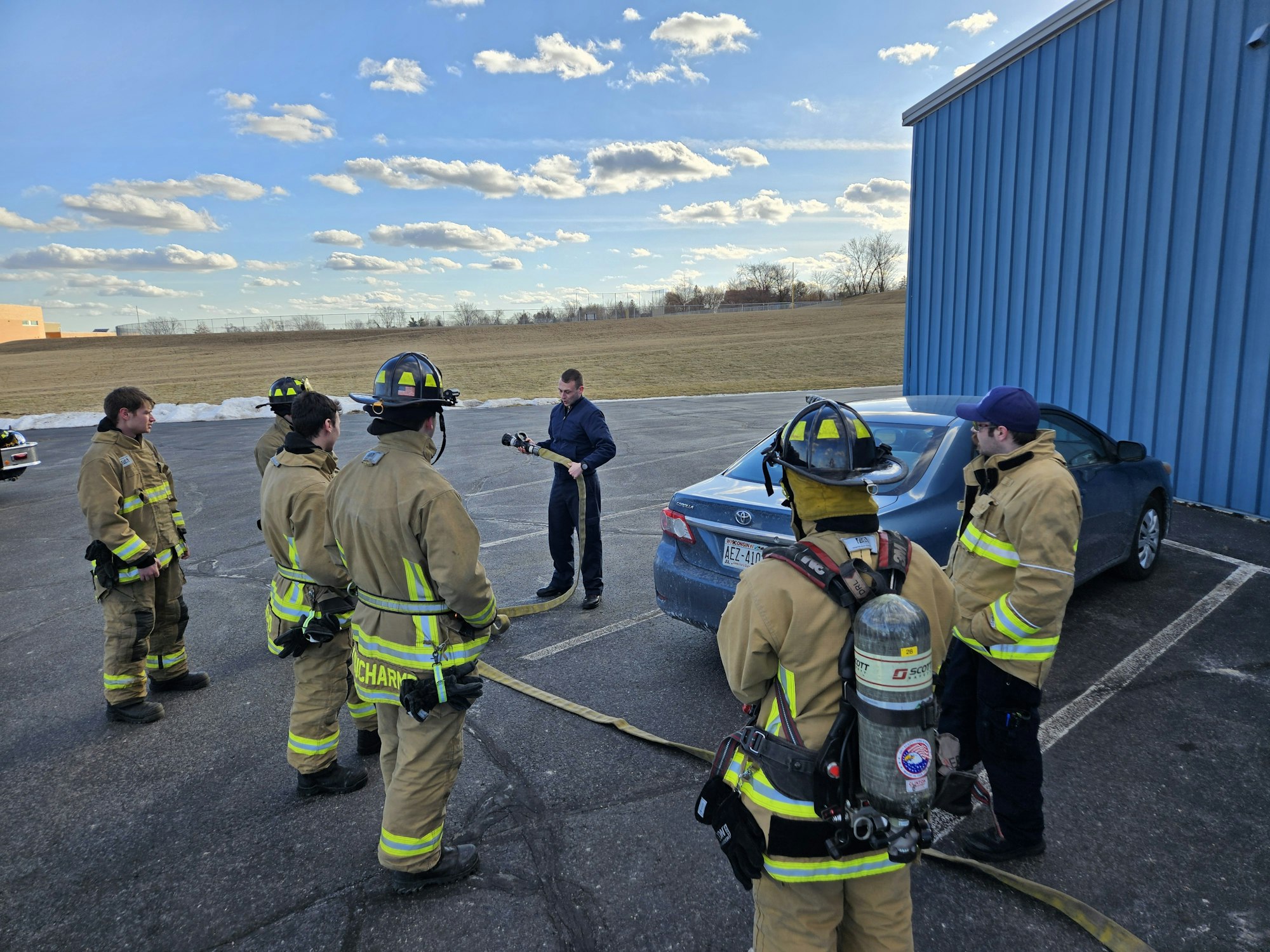 Left to right: Prob Firemen Braxton"Bucket" Messel, Allen Zierfuss, Mark "Dinger" Arnold, Nathan DuCharme, and Blake "Greeny" Greenwell, look on as Lt. Jordan Gustafson goes over how to flake a hoseline with just manipulating the nozzle.