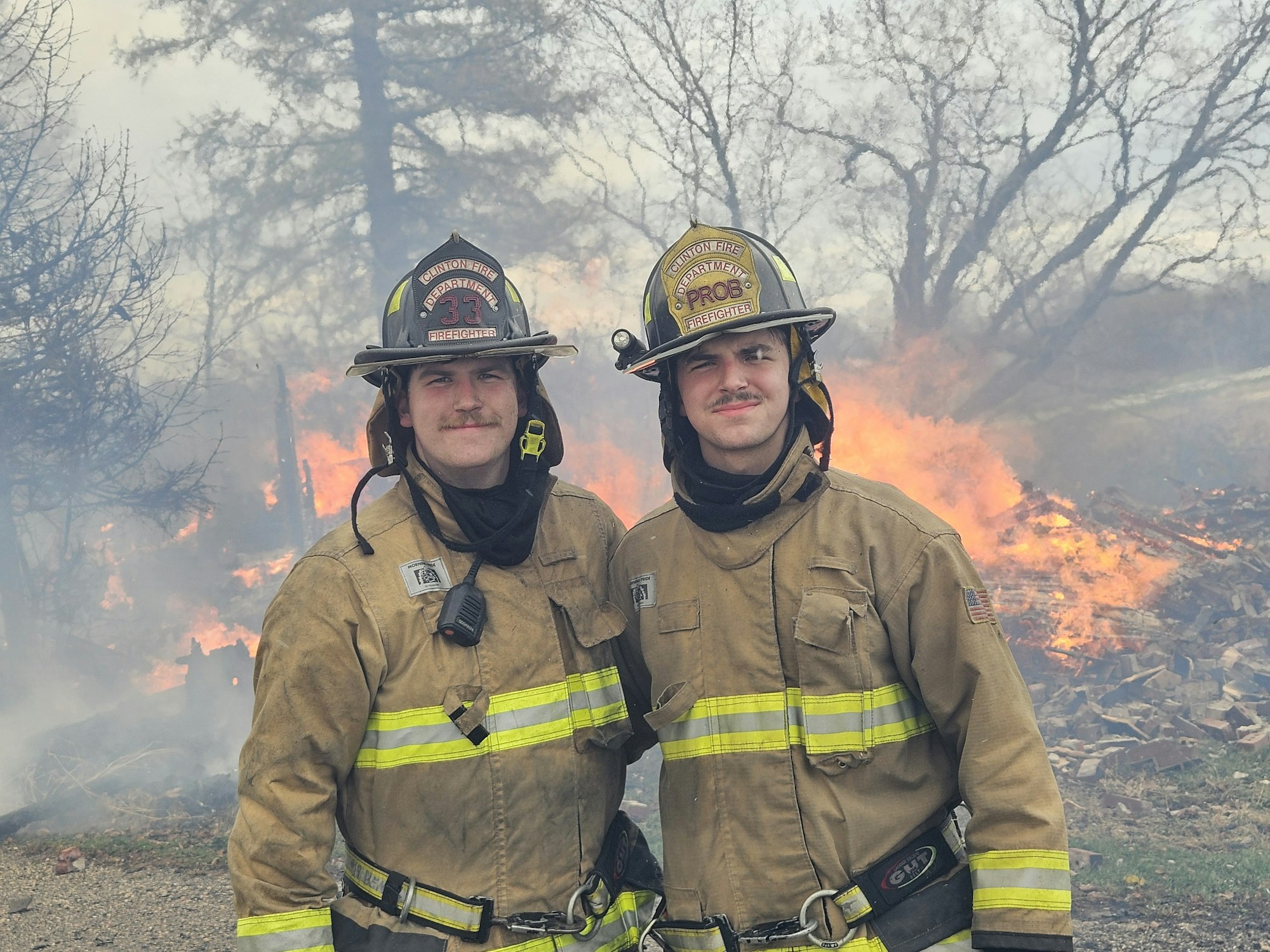 Two firefighters in front of a controlled burn.