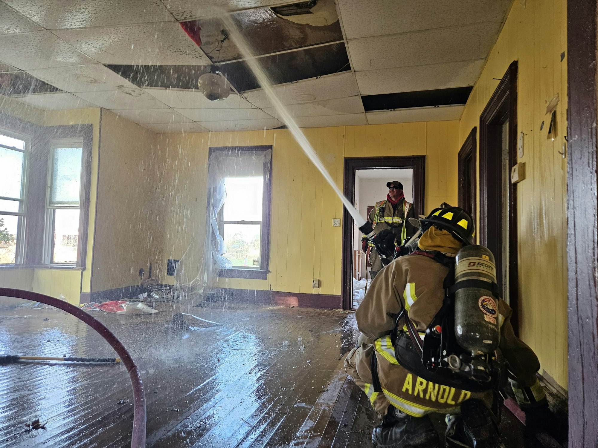 FF/EMR Nick Cary and Probationary FF Mark Arnold flow water into the ceiling to simulate and electrical fire.