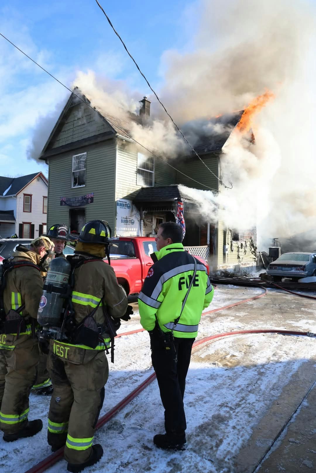 Assistant Chief Farley talks to FF/EMR Brandon West, FF Brandon Kadlec and FF/Medic Erik Olsen on the Mills Street Fire.