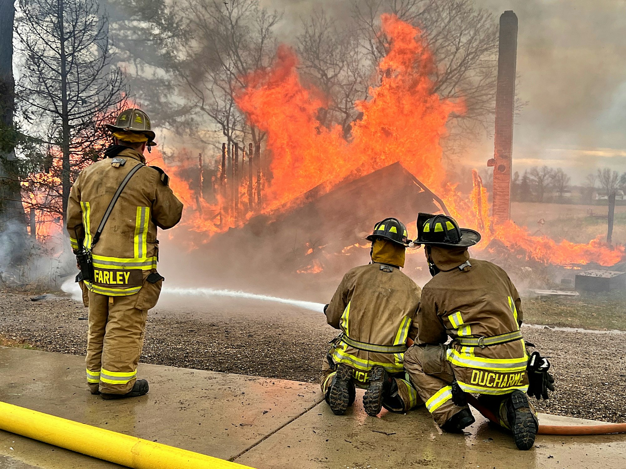 Firefighters battle a blaze in full gear.
