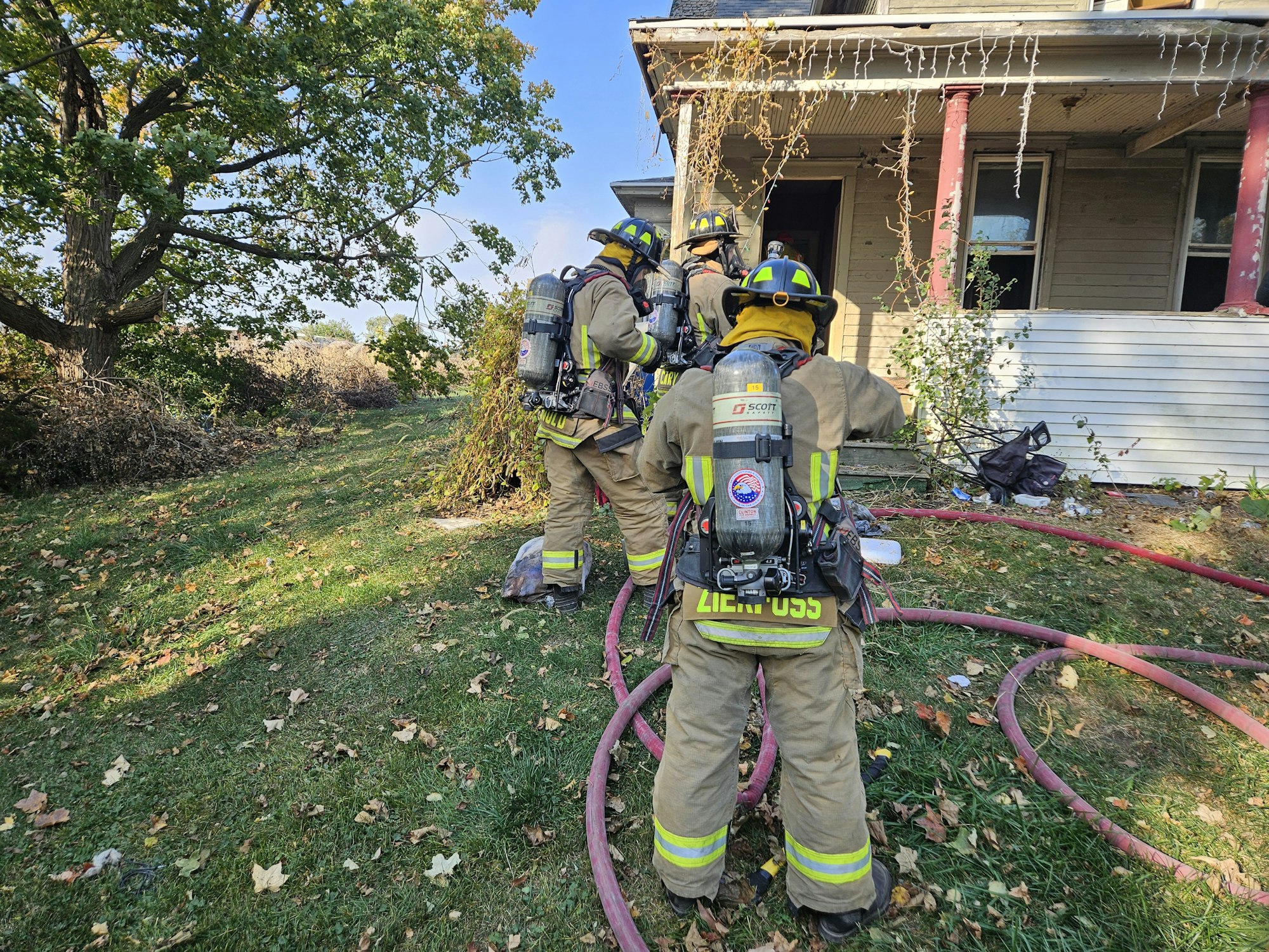 FF/EMR Cary, Probationary FF Arnold, and FF Allen Zierfuss check their gear before entering the building.