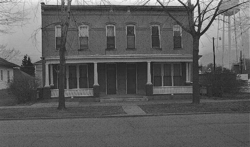 May contain: bench, furniture, neighborhood, architecture, building, house, housing, porch, and brick