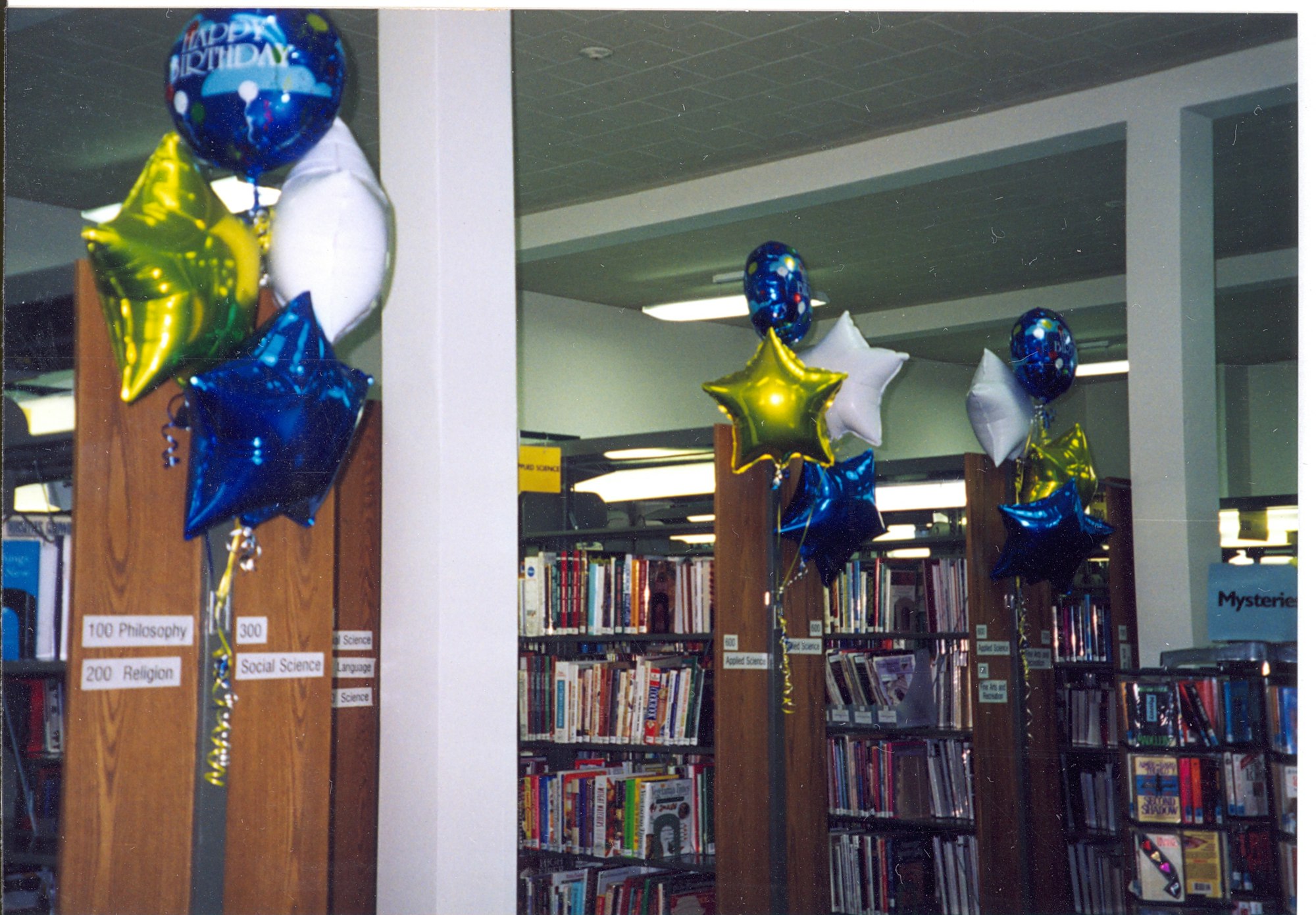 May contain: book, indoors, library, publication, shelf, architecture, building, and balloon