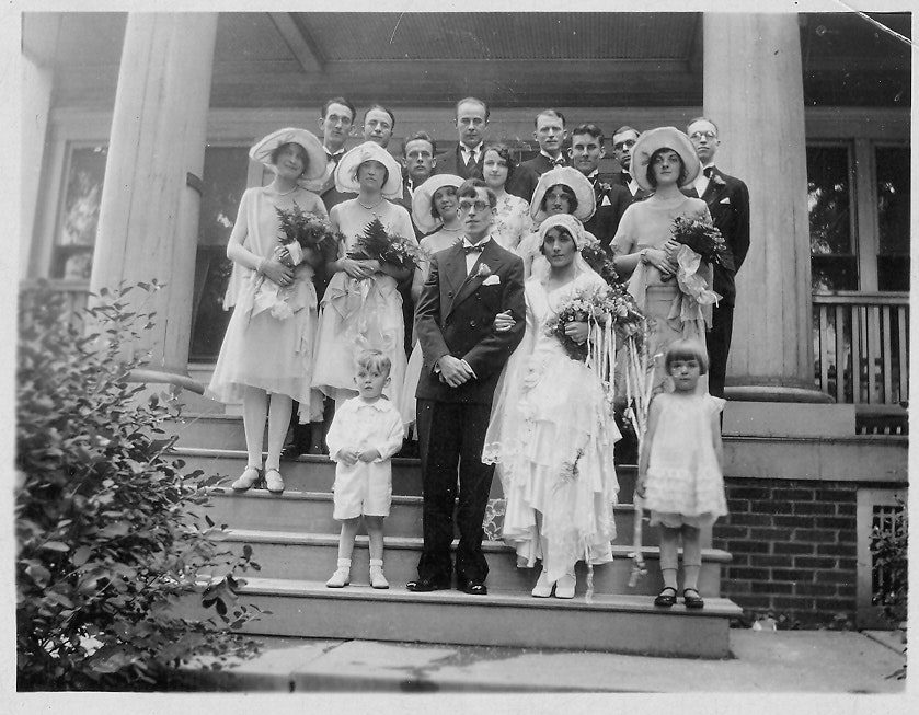 May contain: clothing, dress, formal wear, fashion, gown, suit, face, head, person, photography, portrait, hat, wedding, wedding gown, child, female, girl, adult, bridegroom, male, and man