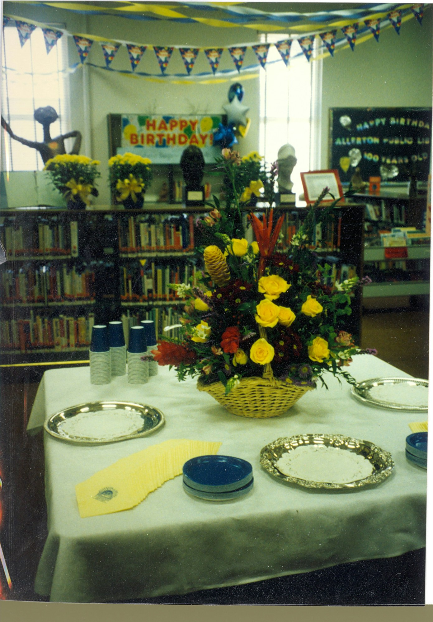 May contain: flower, flower arrangement, plant, flower bouquet, book, publication, dining table, furniture, table, architecture, building, dining room, indoors, room, plate, library, and person