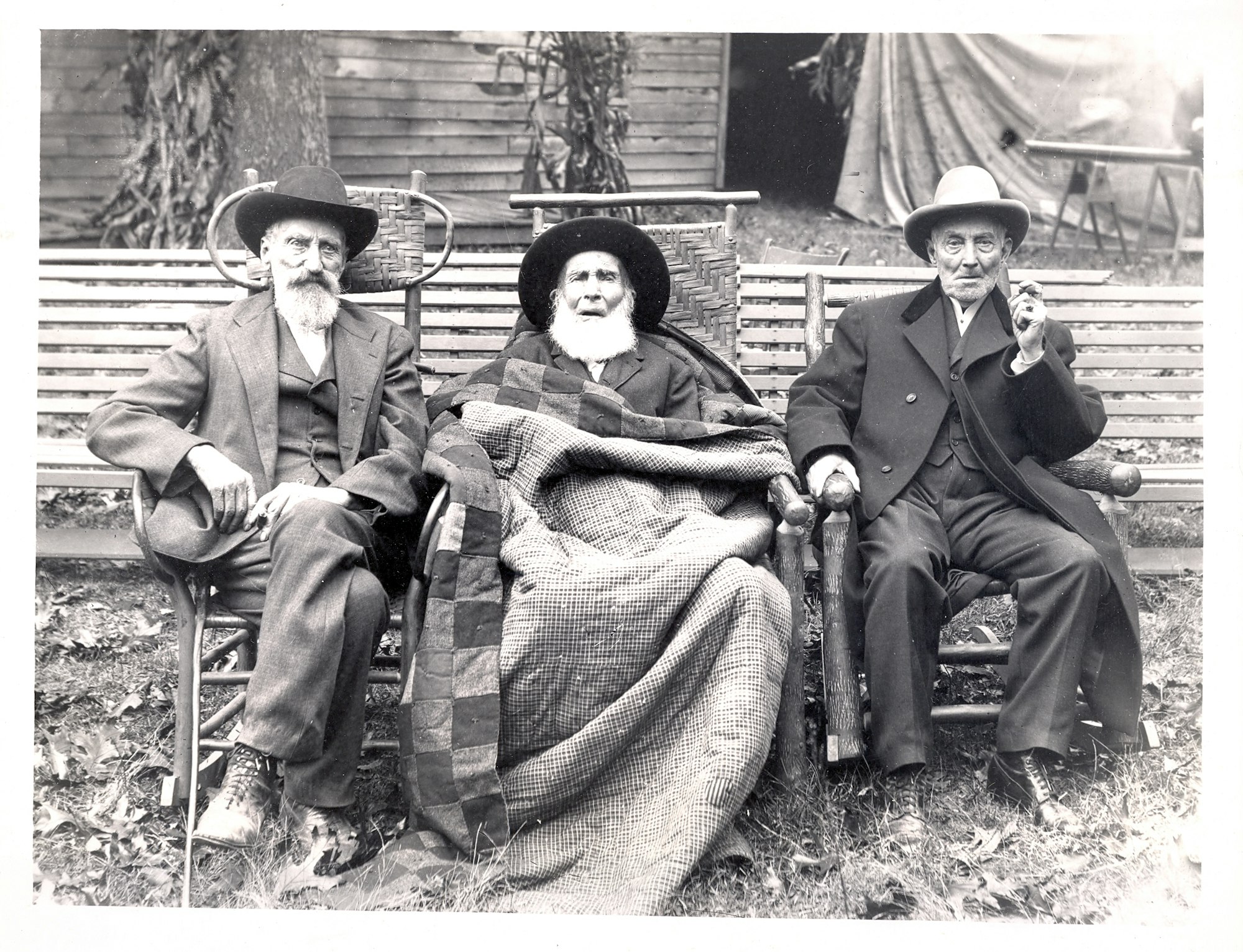 May contain: clothing, hat, bench, furniture, coat, sun hat, adult, male, man, person, and sitting