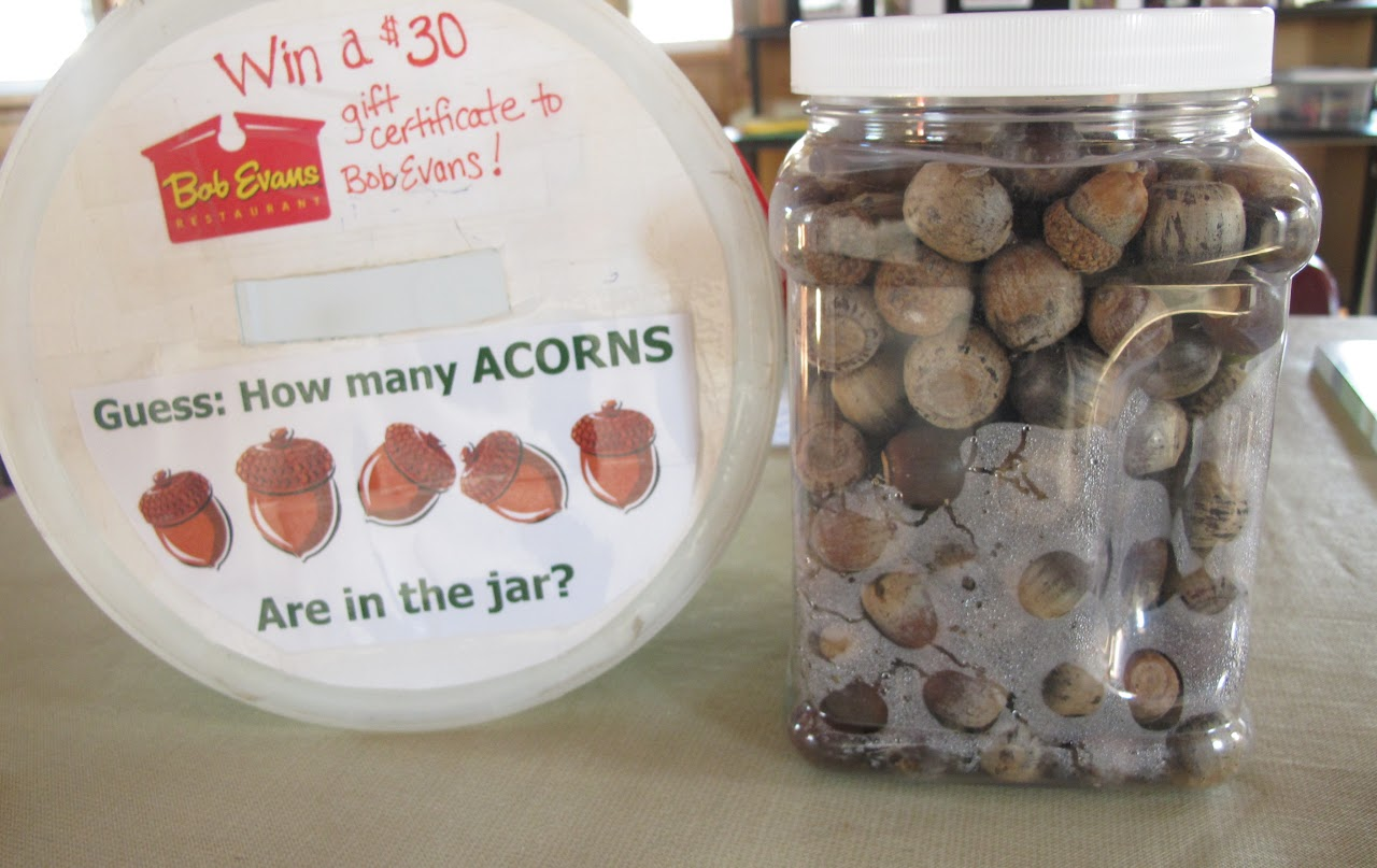 Jar filled with acorns; a sign reads "Guess: How many ACORNS Are in the jar?" Prize: $30 Bob Evans gift certificate.
