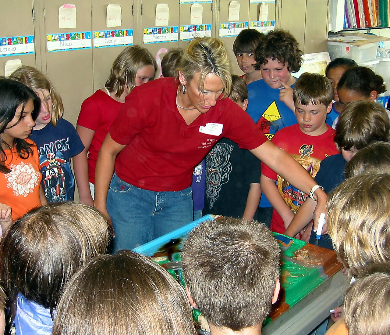 Kelly Riley demonstates pollution on the enviroscape model as students watch the effects of it wash into the streams.