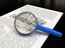 A magnifying glass on a document, zooming in on text.