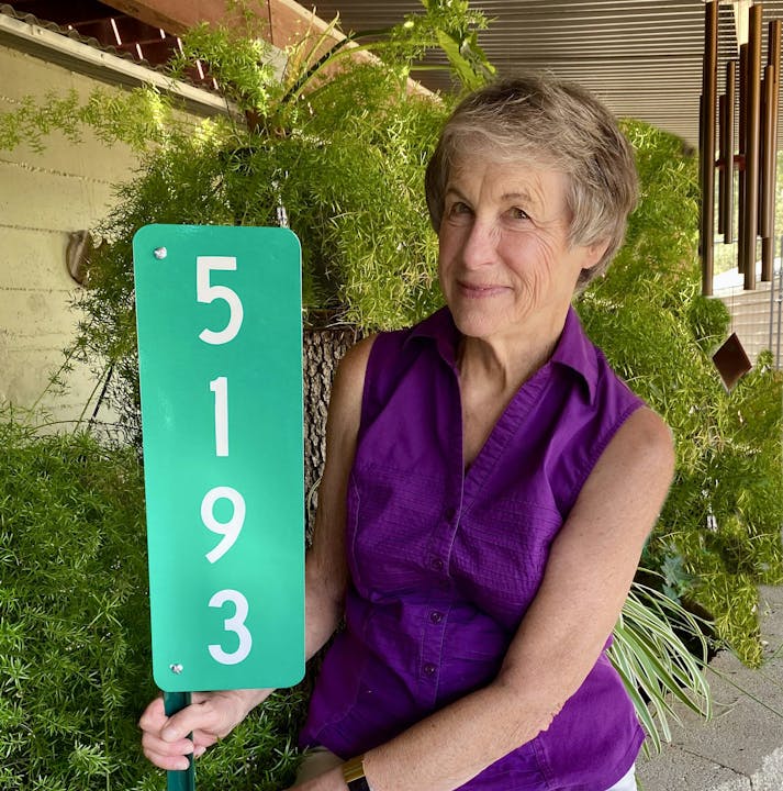 A woman holding a green sign with the number "5193."