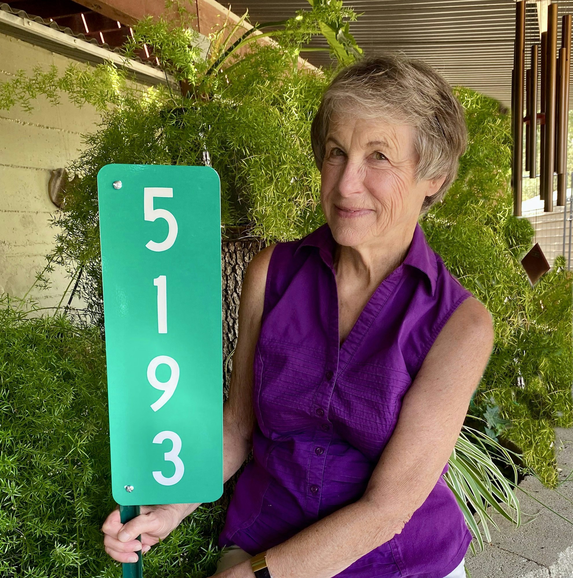 A woman holding a green sign with the number "5193."