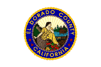 Seal of El Dorado County, California with a historical figure, nature, and "California" on it.