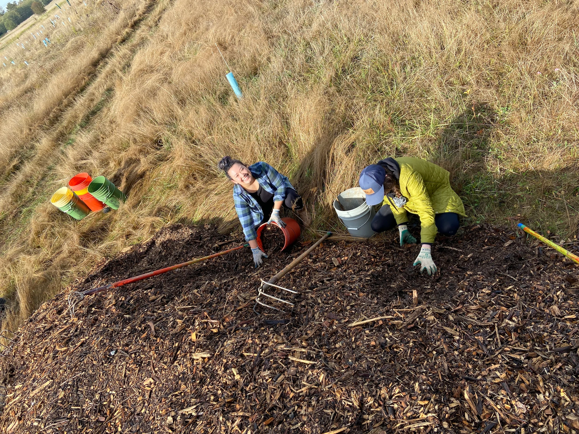 May contain: soil, grass, plant, clothing, glove, field, grassland, nature, outdoors, face, head, person, photography, portrait, slope, and planting