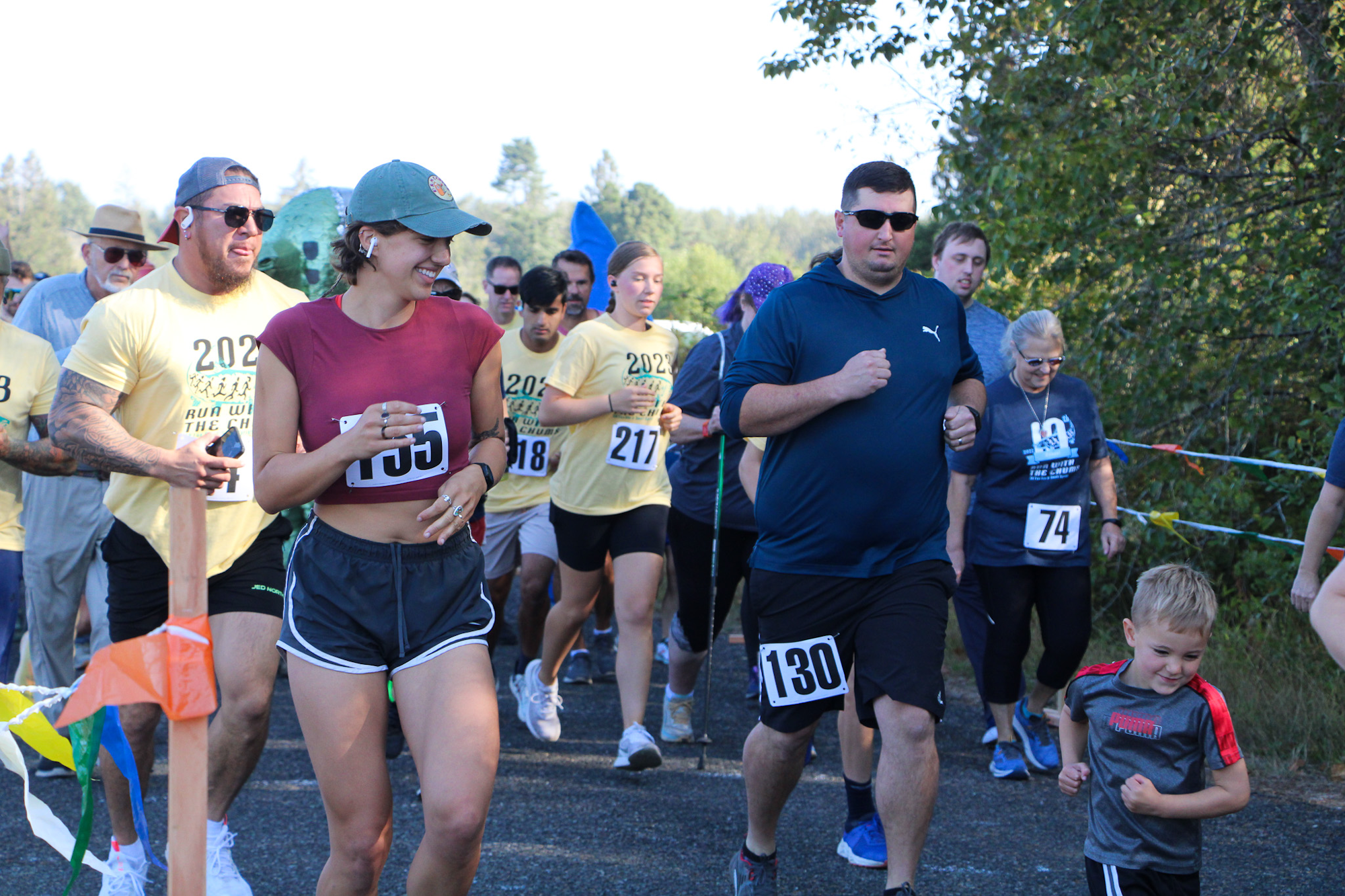A group of people participating in a running event, wearing numbered bibs and athletic wear.