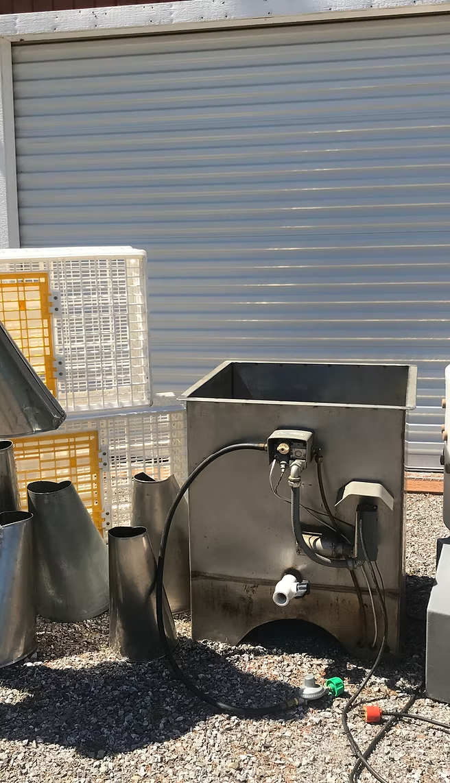Metal cones, tank with cables, white crates, and a rolled-up garage door background.