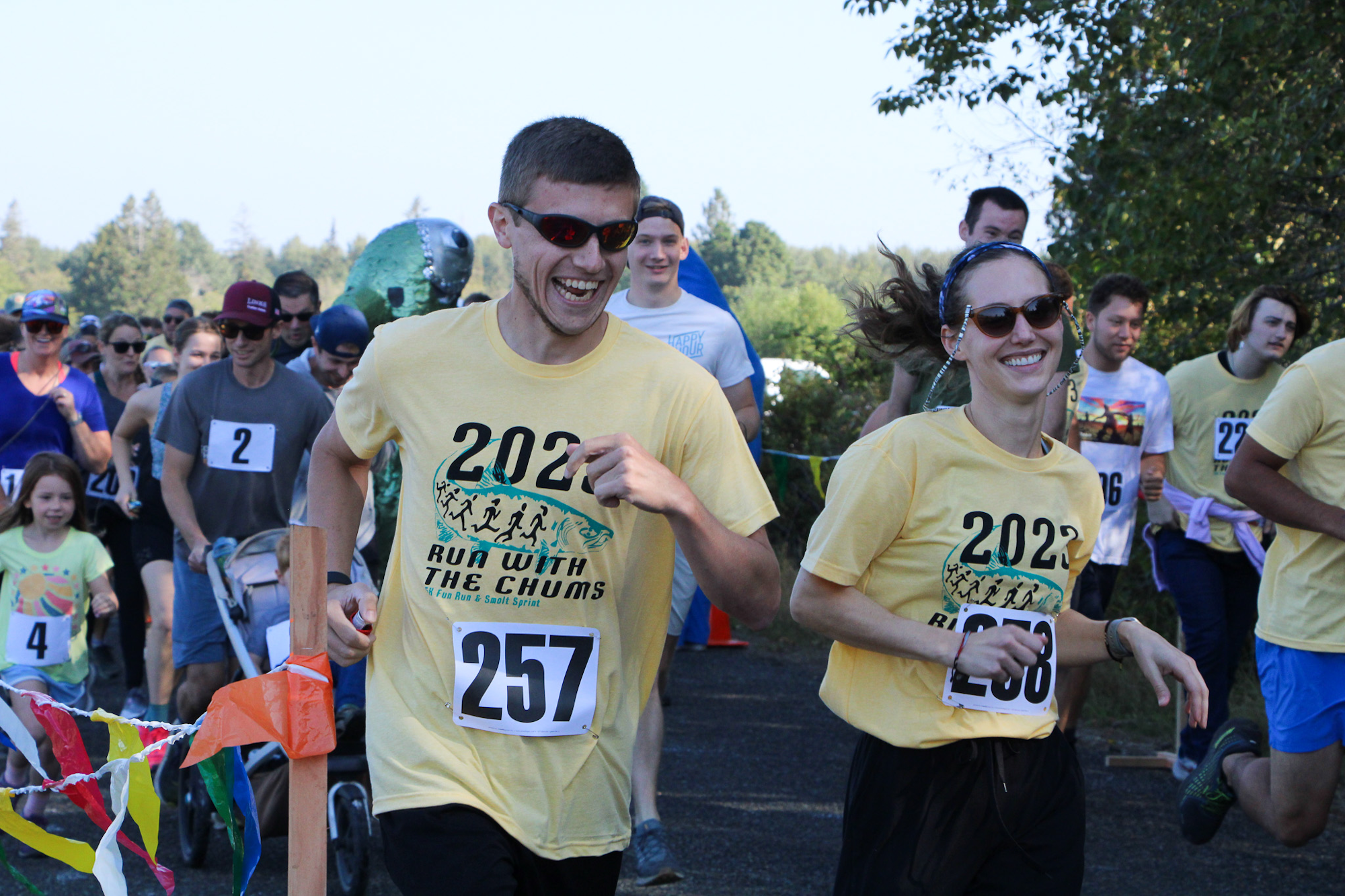 People in yellow shirts with numbers are running at an event called "Run with the Chums" in 2022.