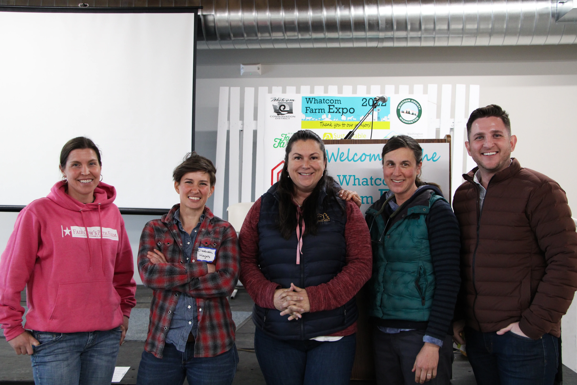 Five people posing together at the Whatcom Farm Expo event.
