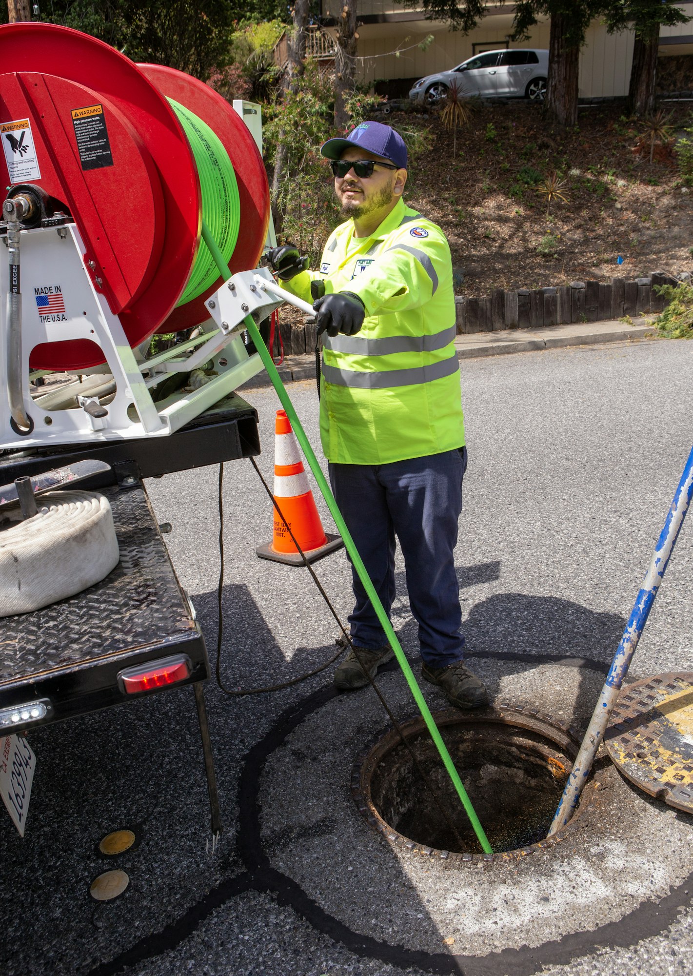 May contain: person, worker, clothing, glove, hardhat, helmet, hole, footwear, shoe, hat, accessories, glasses, car, transportation, vehicle, and drain