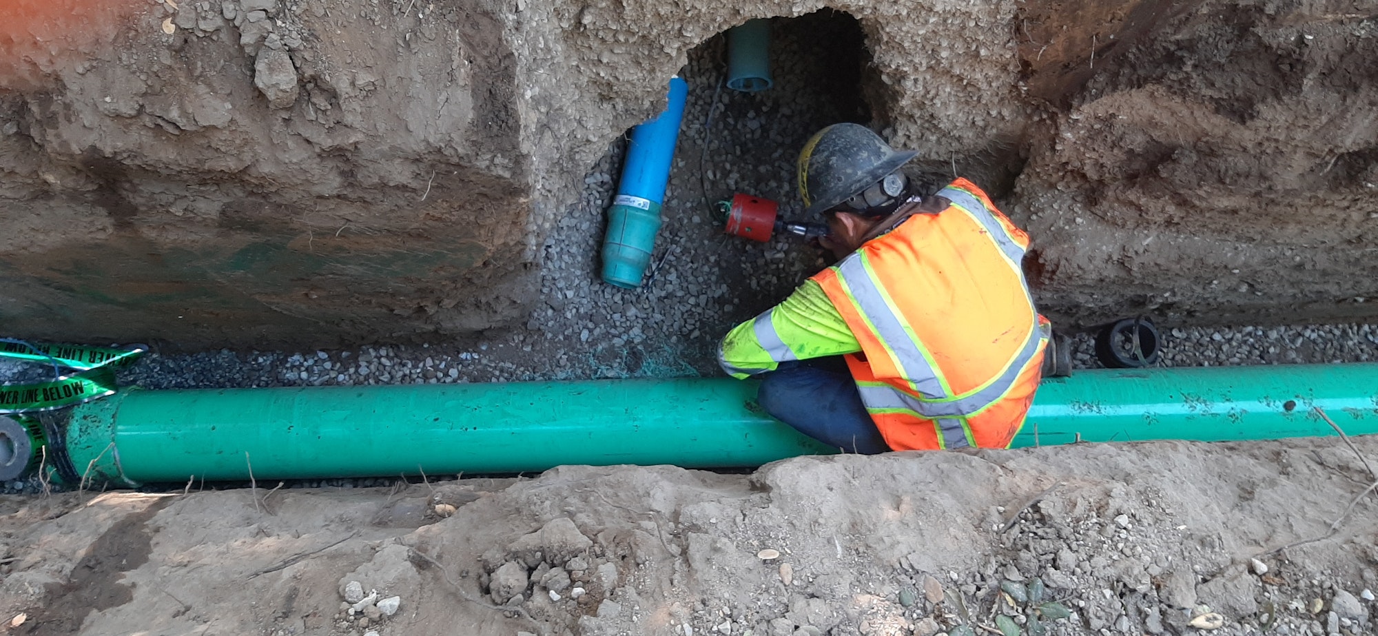 May contain: soil, hardhat, pipes, and person