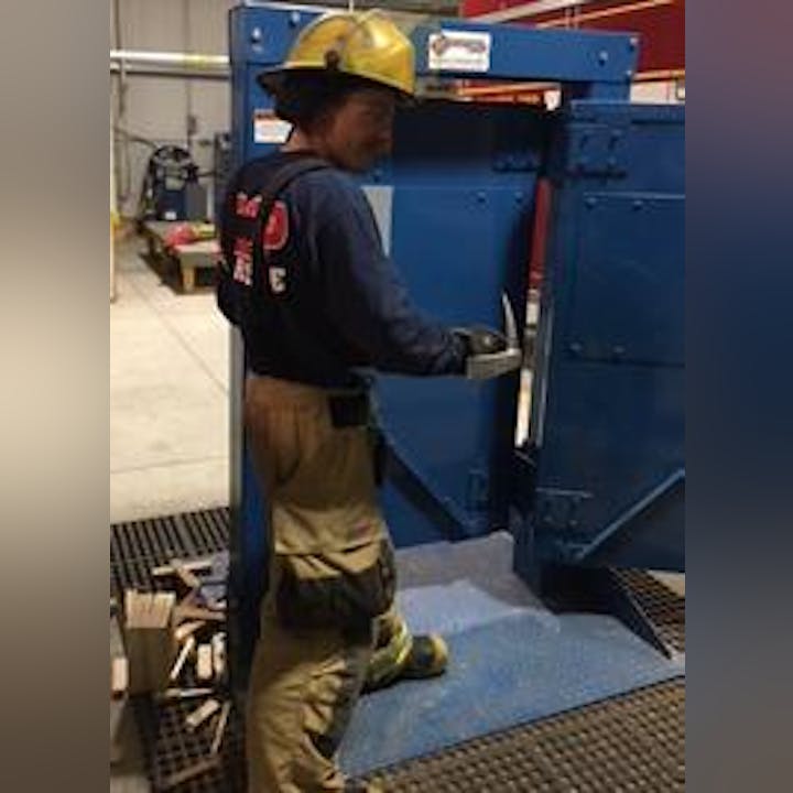 A firefighter in gear is operating machinery.