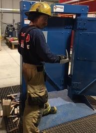 A firefighter in gear is operating machinery.