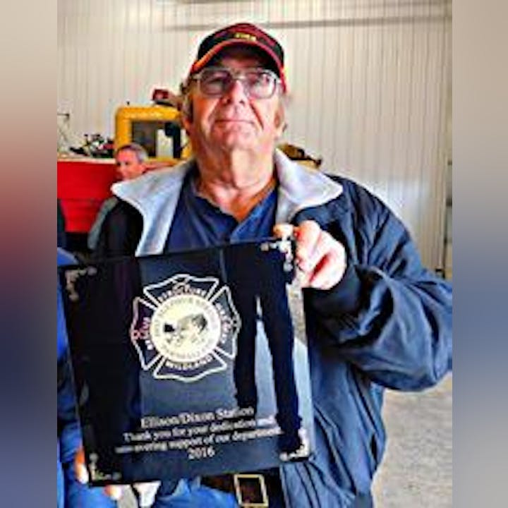 A person holding a plaque with a key, showing appreciation for years of service in 2016.