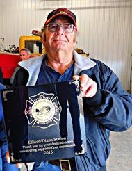 A person holding a plaque with a key, showing appreciation for years of service in 2016.