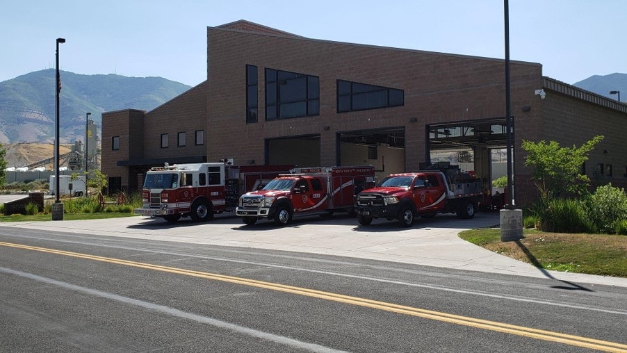 Fire station with emergency vehicles parked outside.
