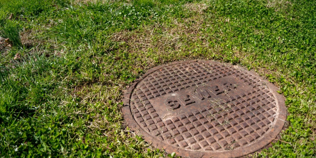 May contain: hole, sewer, grass, plant, drain, manhole, wheel, and machine