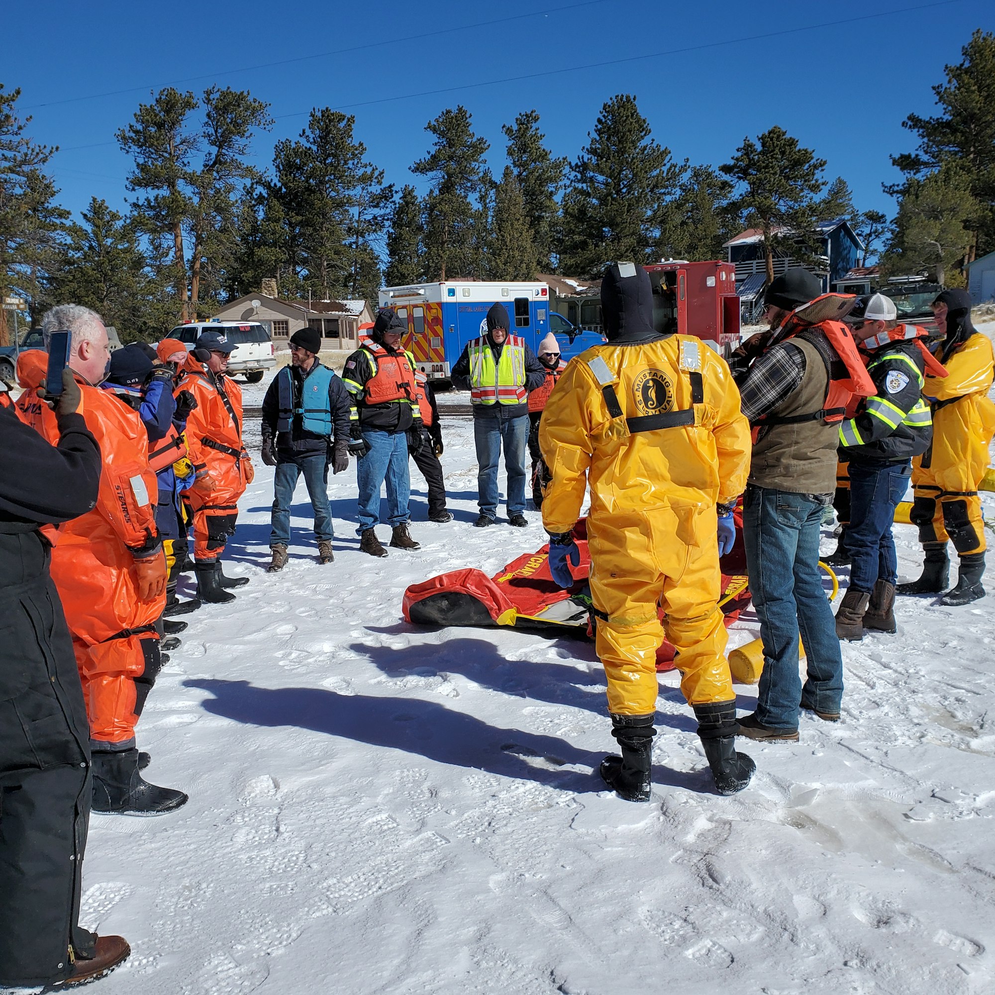 May contain: clothing, glove, footwear, shoe, person, hat, worker, coat, adult, male, man, rescue, car, transportation, and vehicle