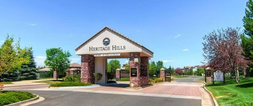 Entrance to Heritage Hills community with brick columns and greenery.